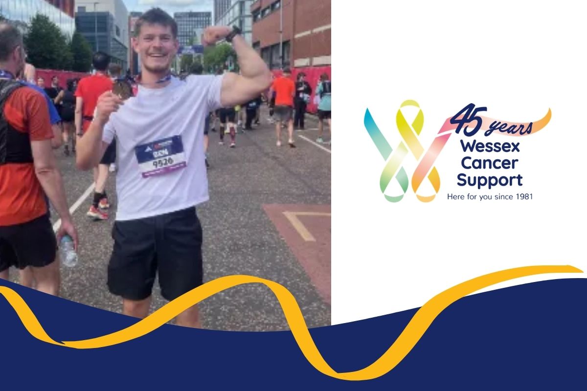 photo shows Ben holding up one arm and a medal in the other hand, wearing running outfit and smiling to camera